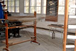 Fäden werden zur Webmaschiene geführt.